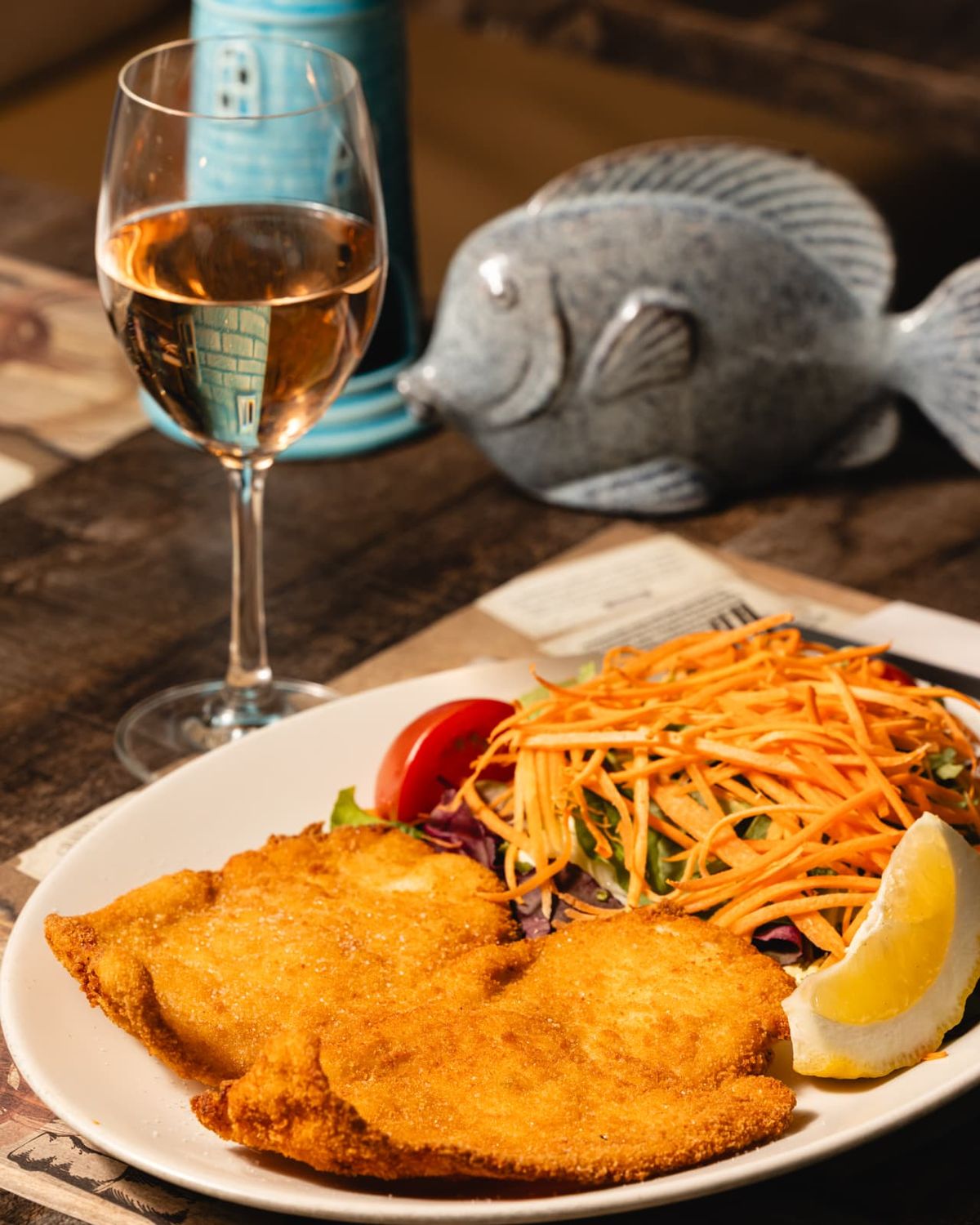 Breaded fried fish with salad and a glass of rosé